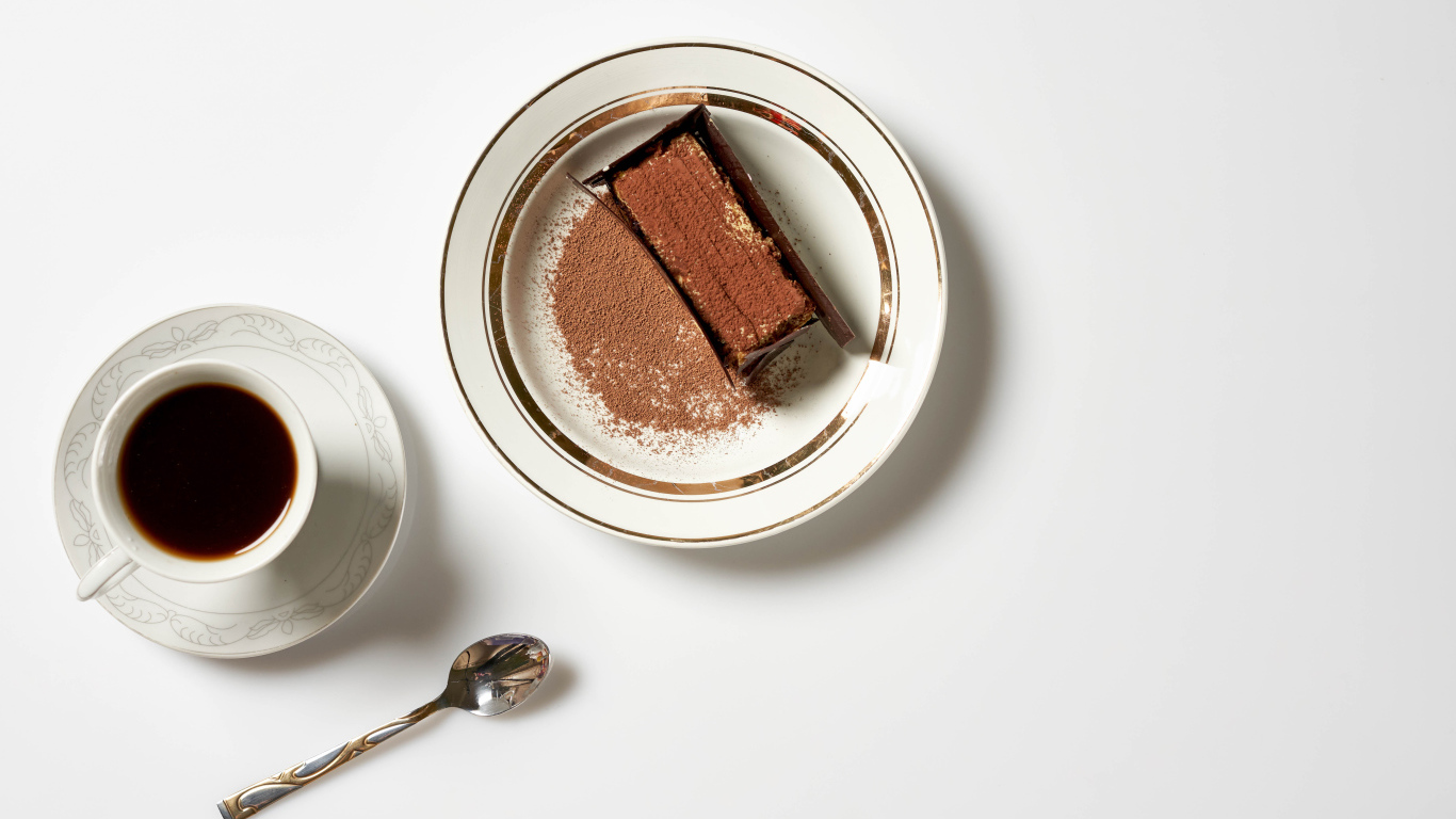 Кусок торта на столе с чашкой кофе 