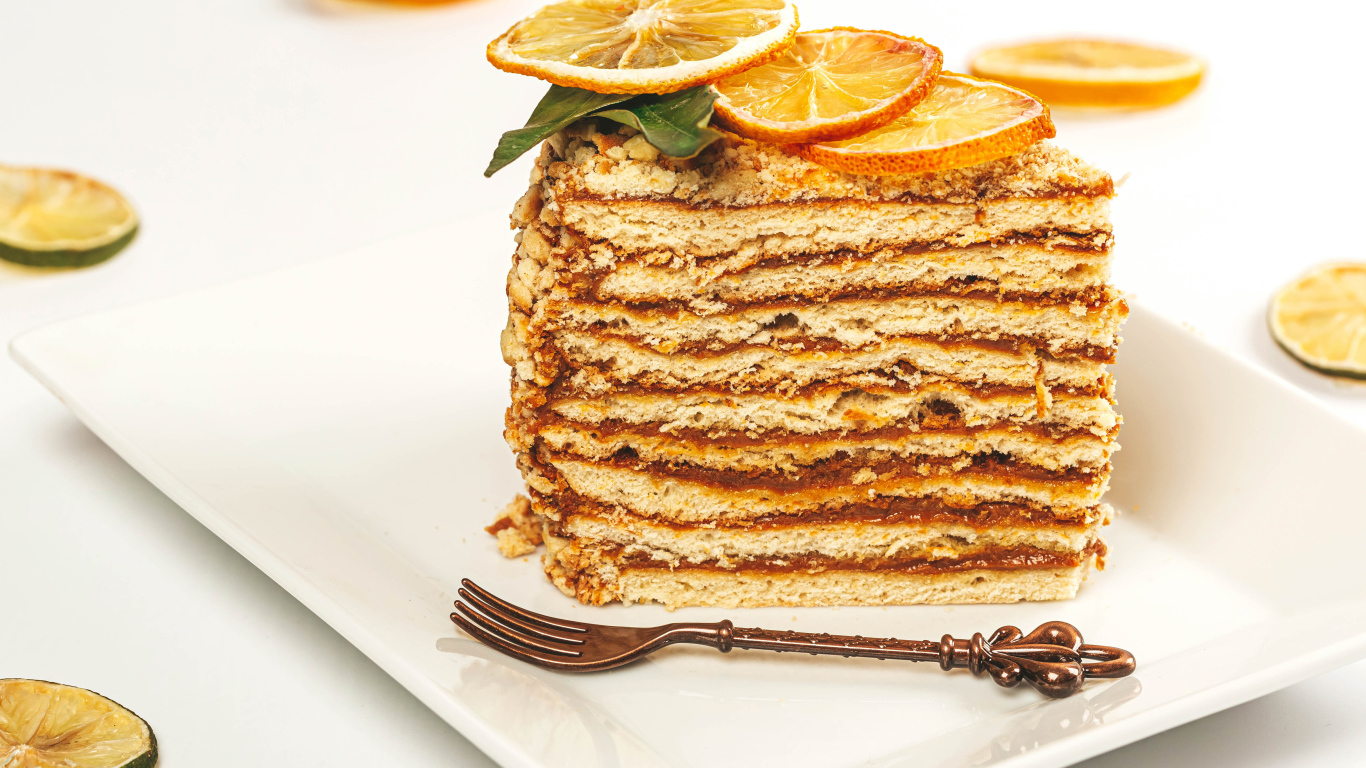 Кусок торт с сушеными лимонами на белой тарелке