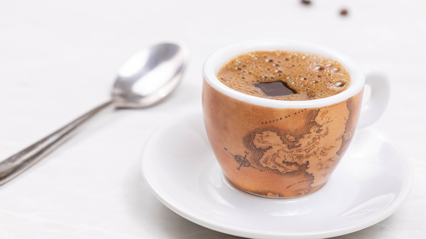 Cup of hot coffee on the table with a spoon