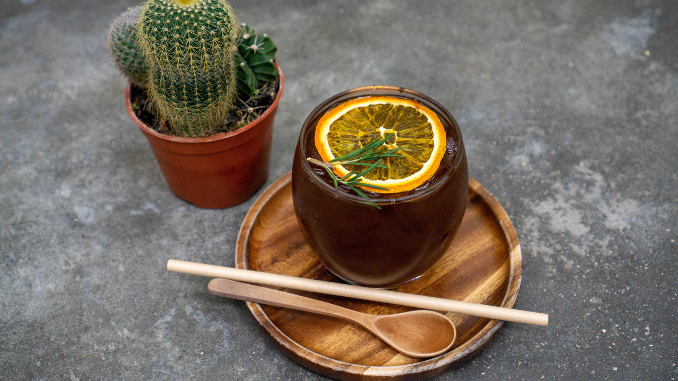 Чай с лимоном на столе с колючим кактусом