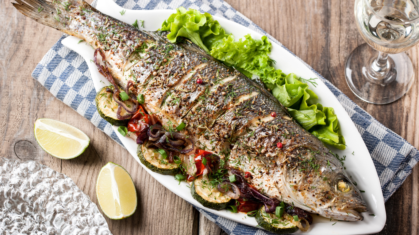 Большая запеченная рыба с кабачками и листьями салата