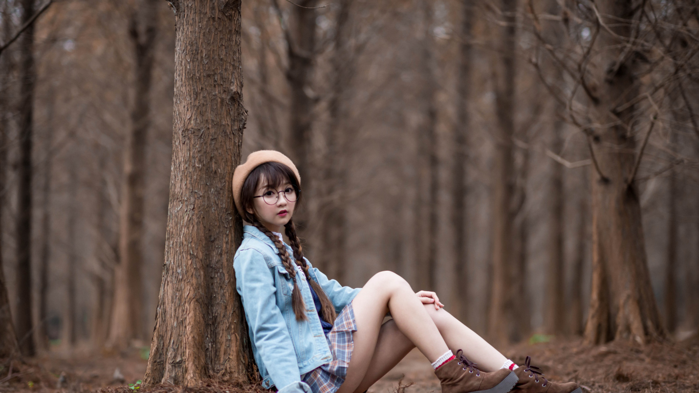 Девушка азиатка школьница сидит под деревом