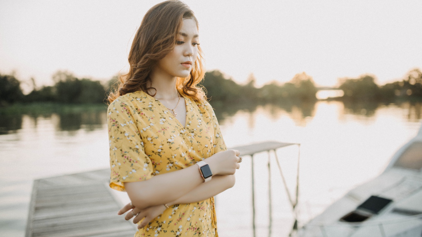 Красивая девушка азиатка стоит у реки 