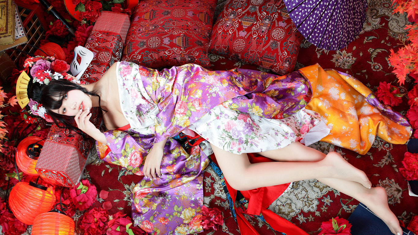 Красивая девушка азиатка в кимоно лежит на полу