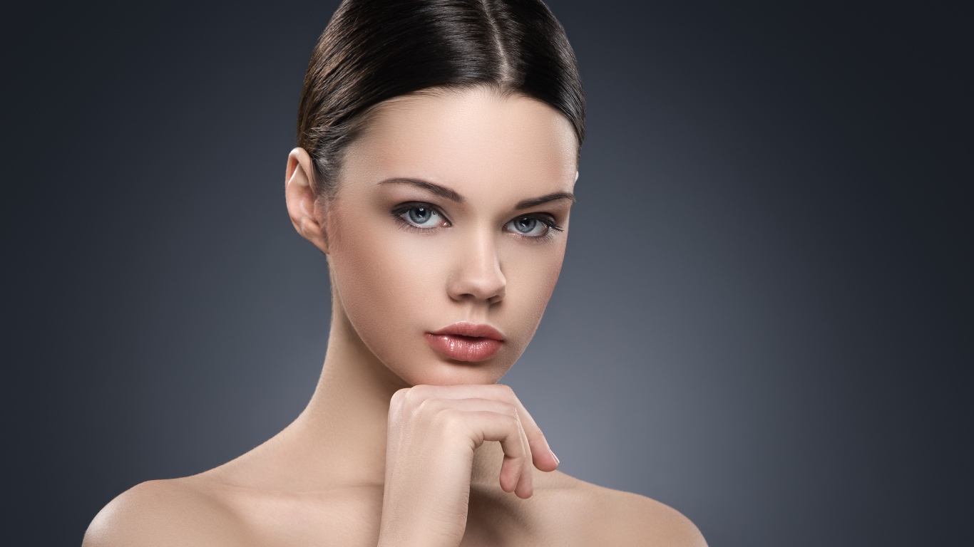 Красивая голубоглазая девушка на сером фоне 