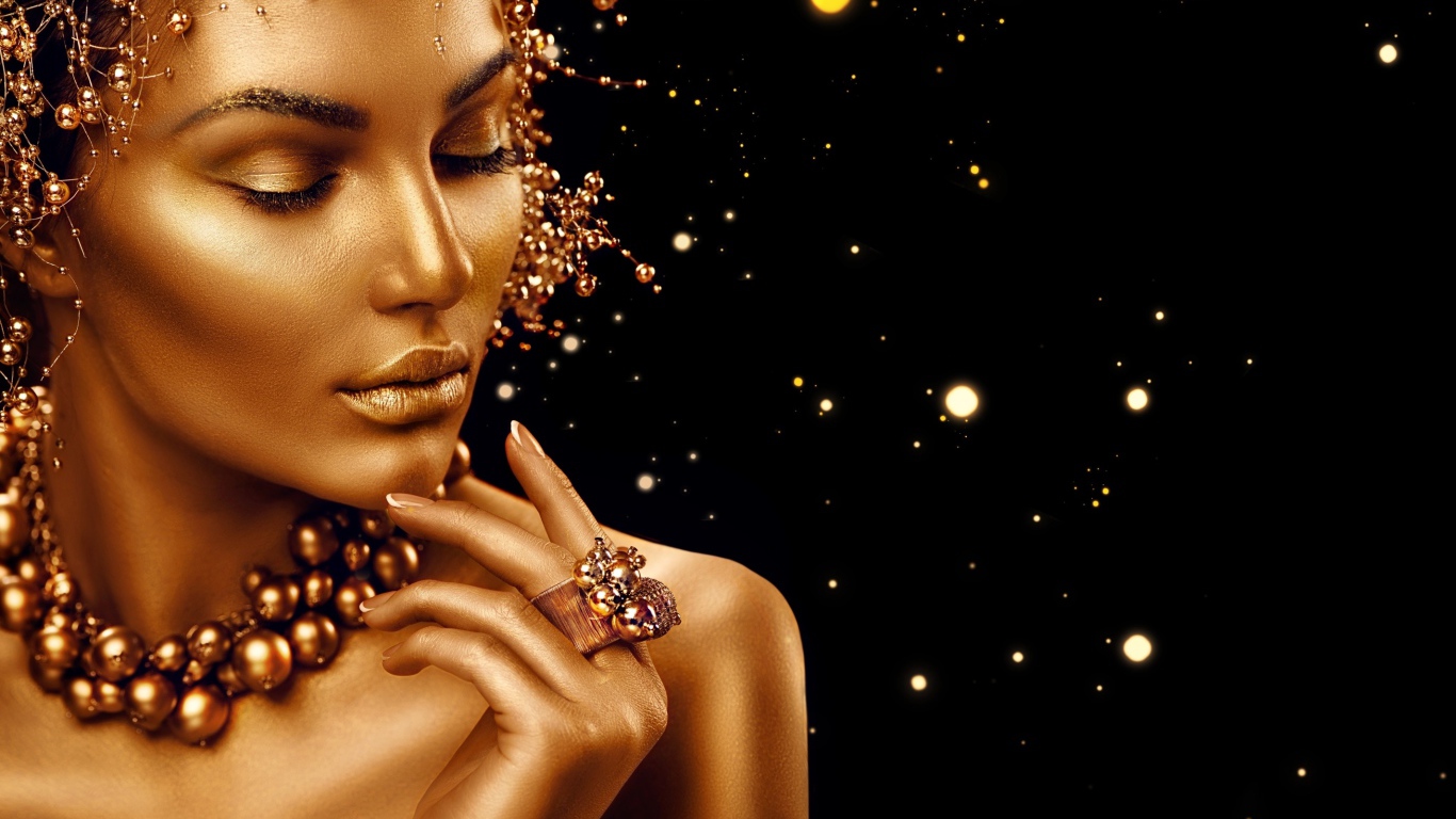 Красивая девушка в золотой краске на черном фоне