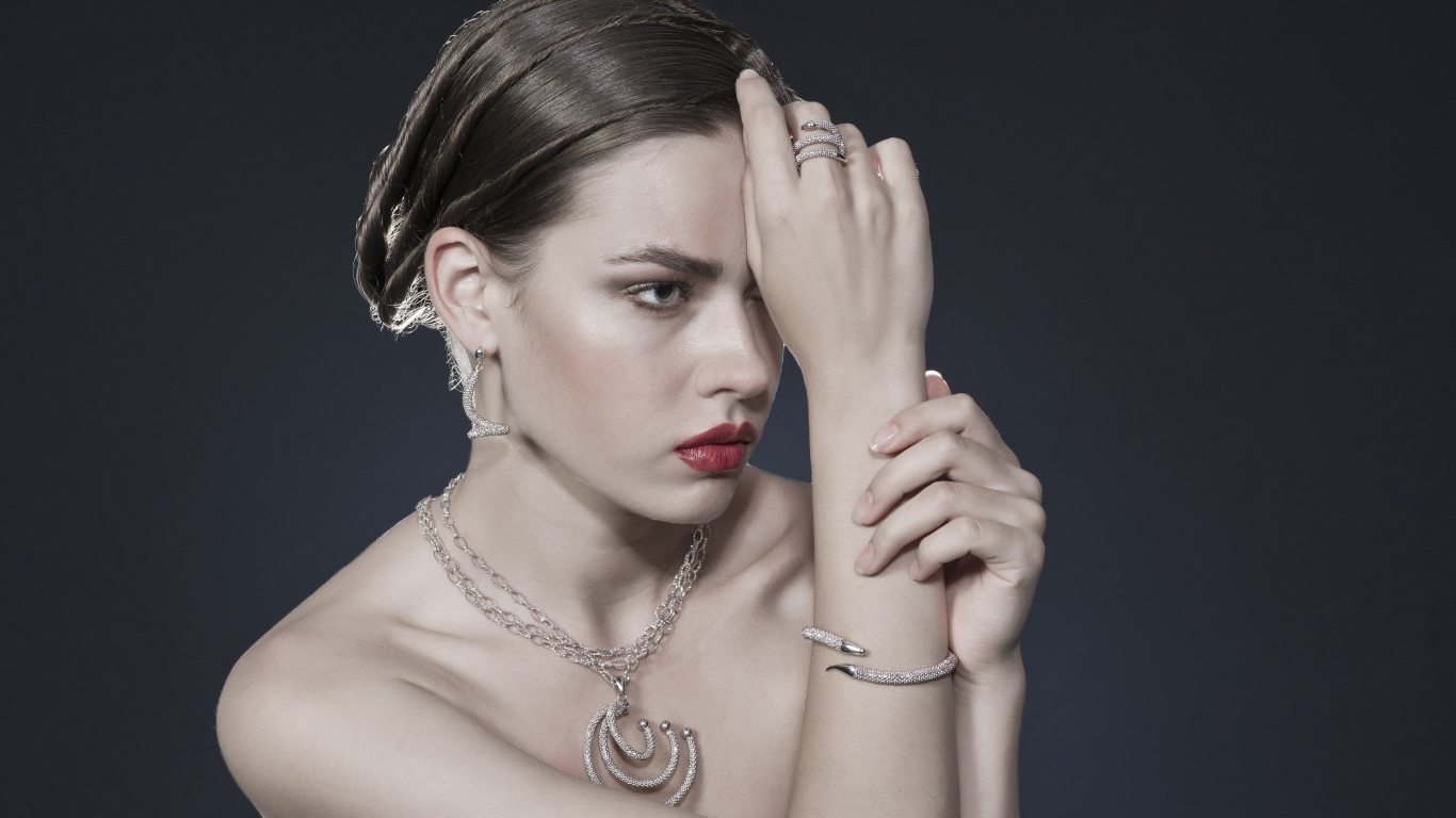 Красивая девушка с украшениями на теле на сером фоне