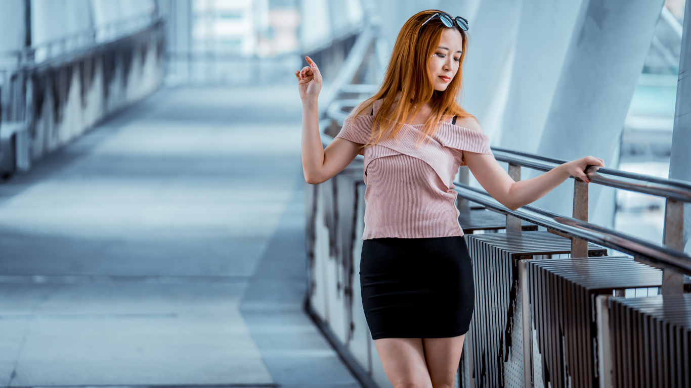 Красивая рыжеволосая девушка азиатка в черной юбке