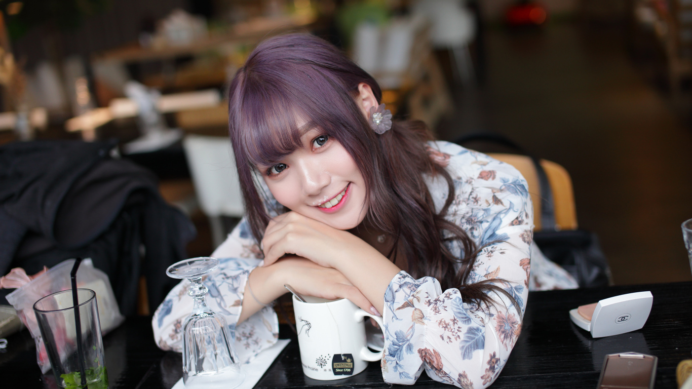 Милая девушка азиатка сидит за столиком