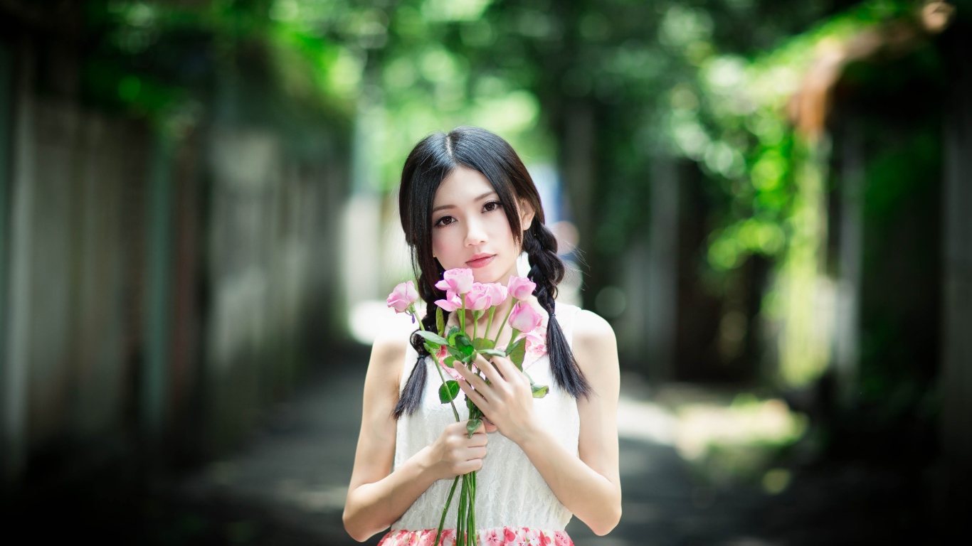 Милая девушка азиатка с букетом розовых роз 