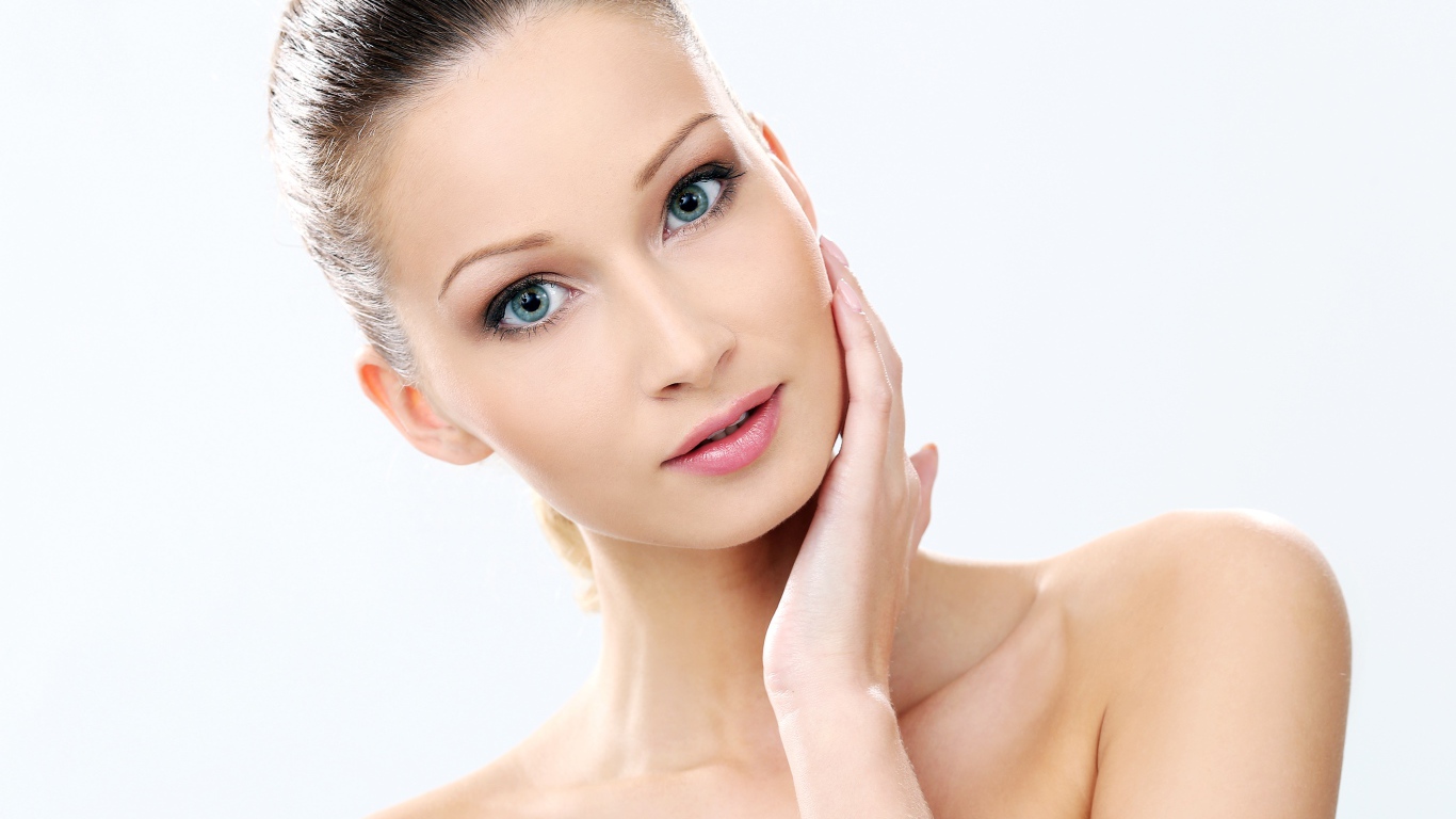 Нежная голубоглазая девушка без макияжа на белом фоне