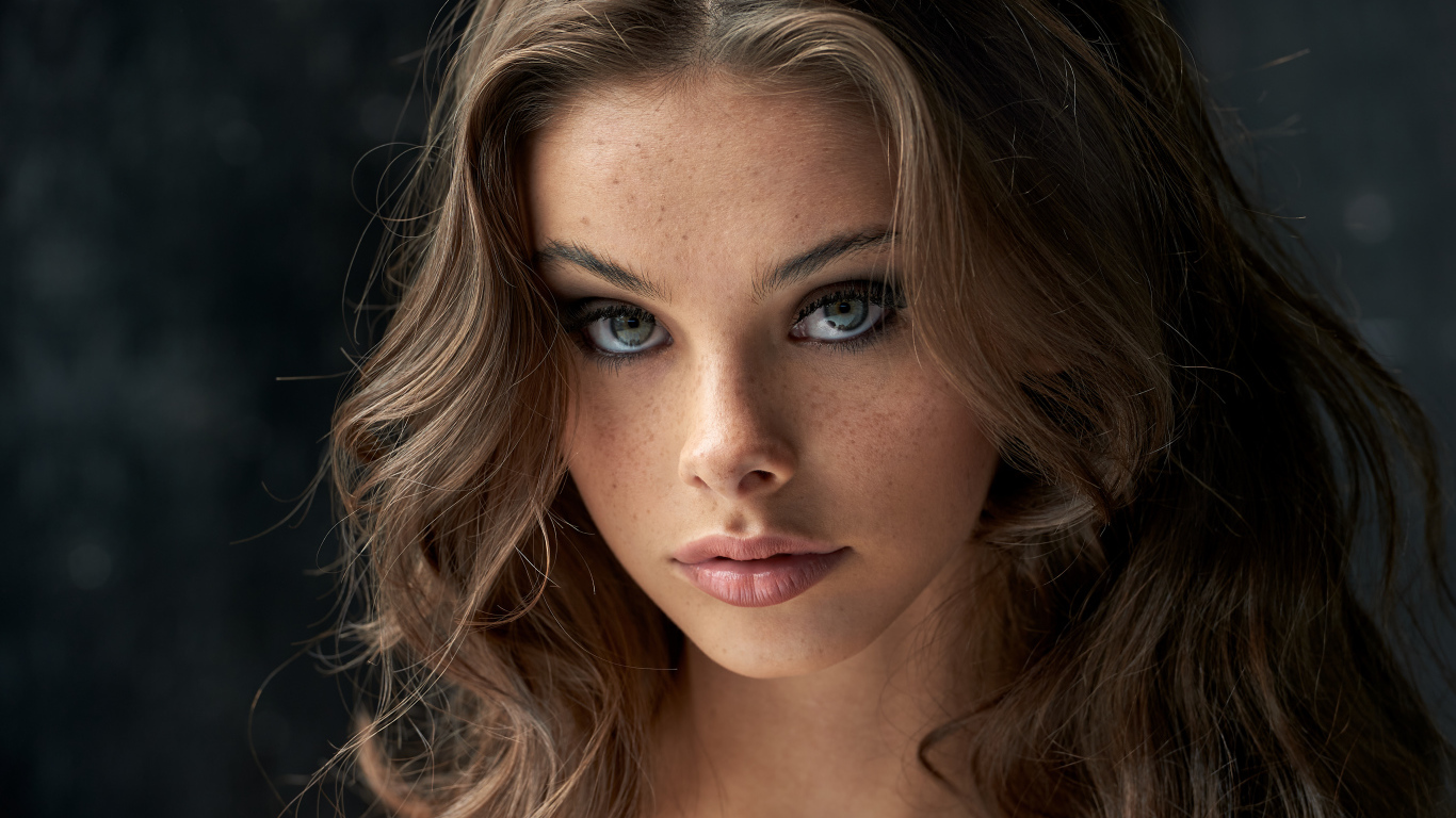 Лицо красивой девушки с веснушками на лице 