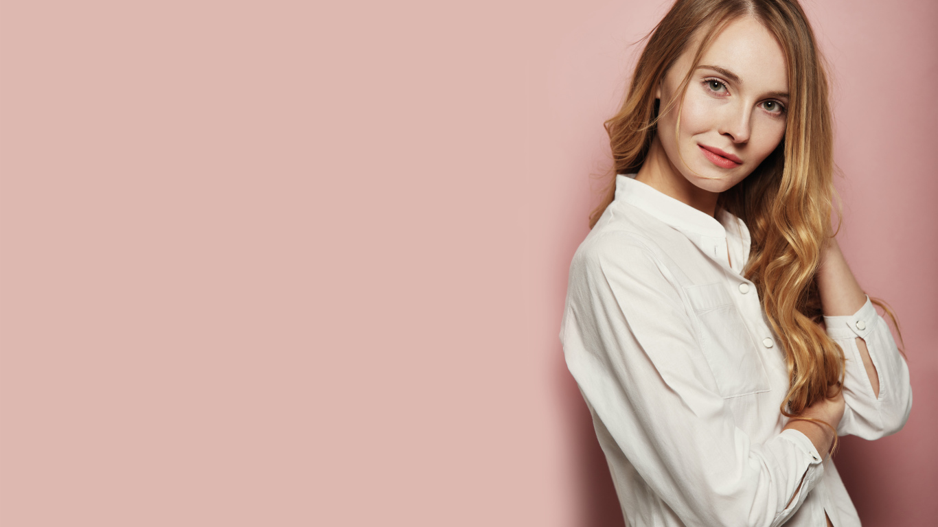 Девушка в белой рубашке на розовом фоне