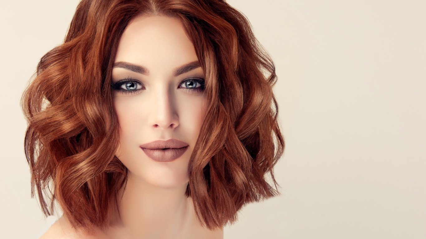 Рыжеволосая голубоглазая девушка на сером фоне