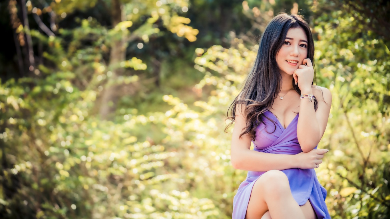 Улыбающаяся девушка азиатка в сиреневом платье