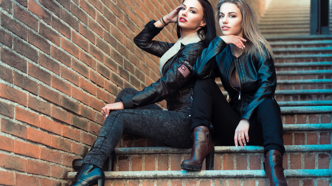 Две красивые девушки сидят на ступенях 