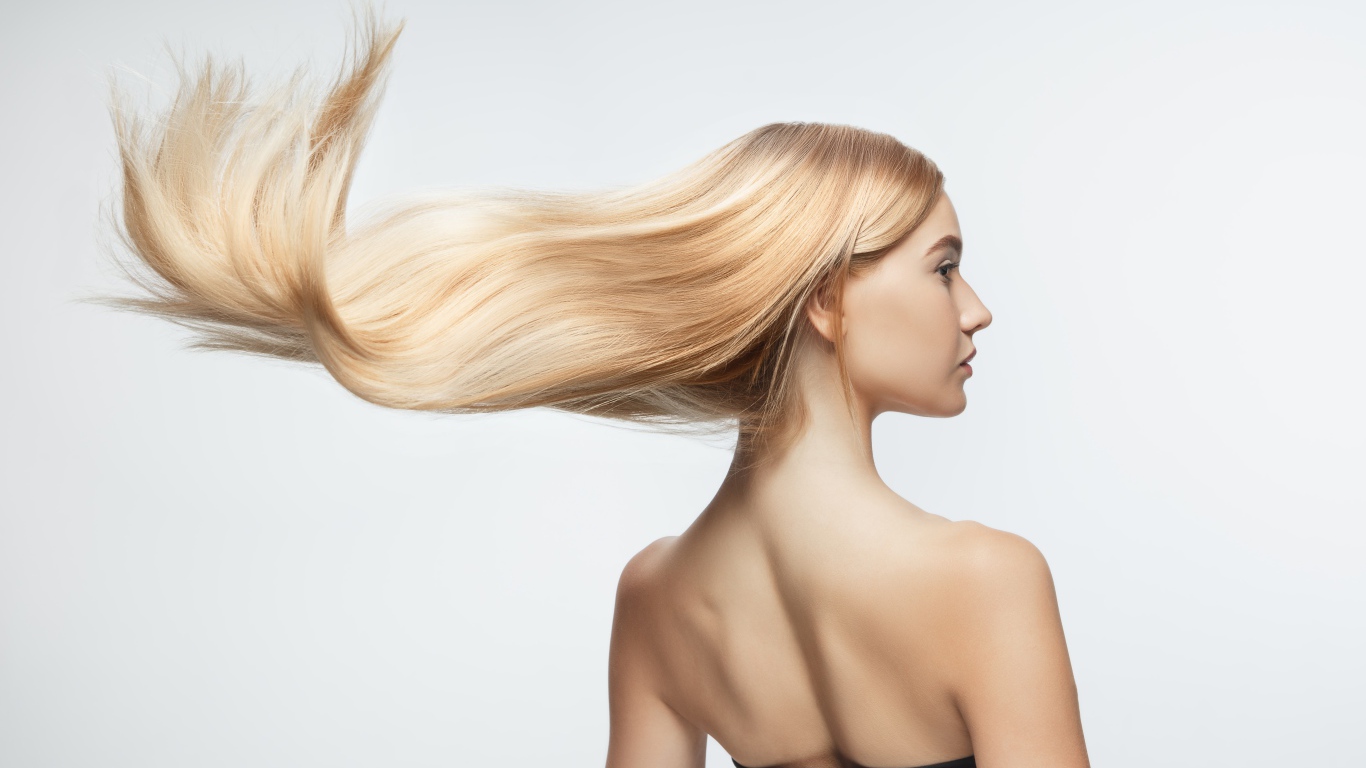 Белые волосы девушки развиваются на белом фоне 