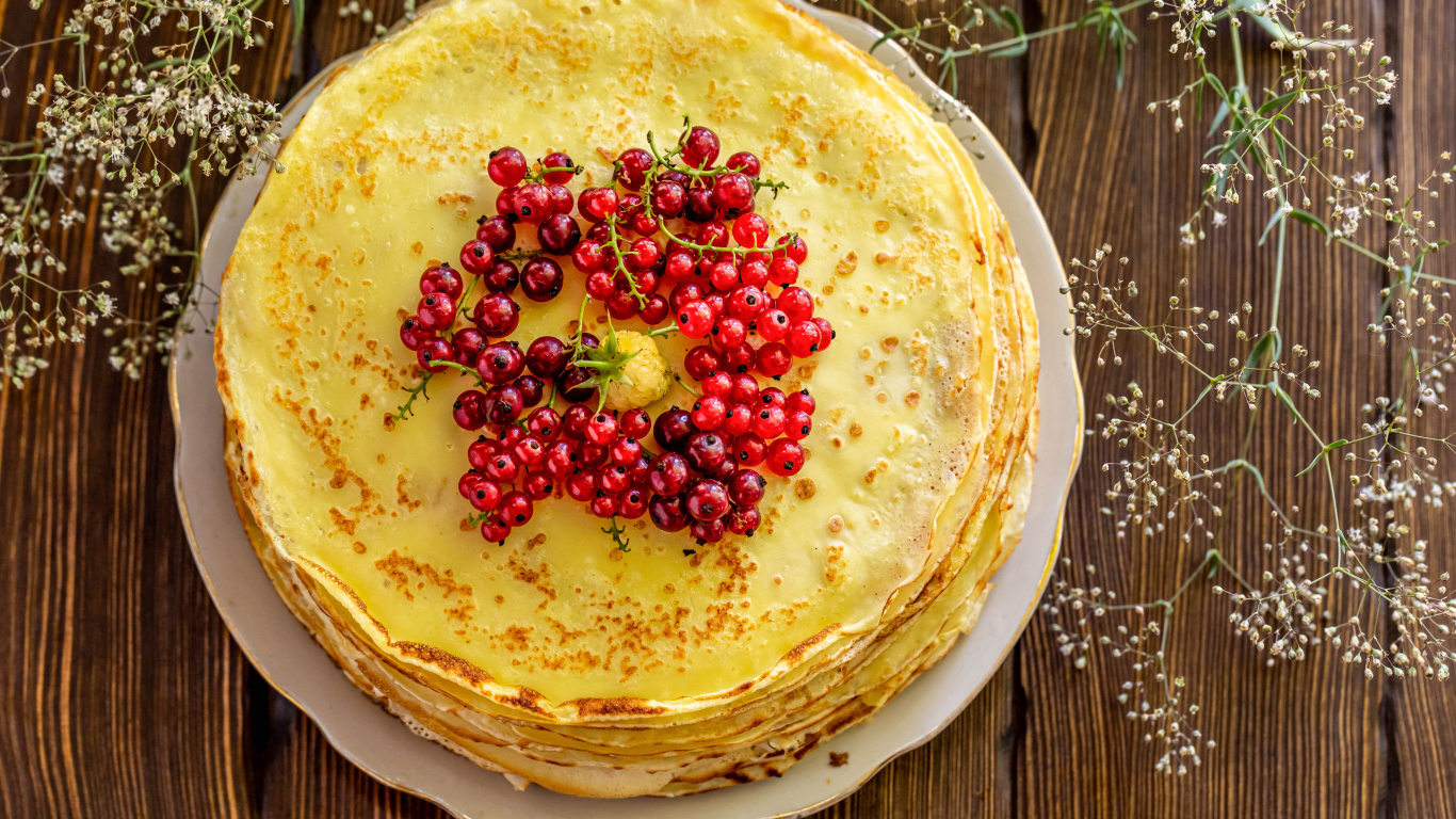 Аппетитные блины с ягодами красной смородины на столе 