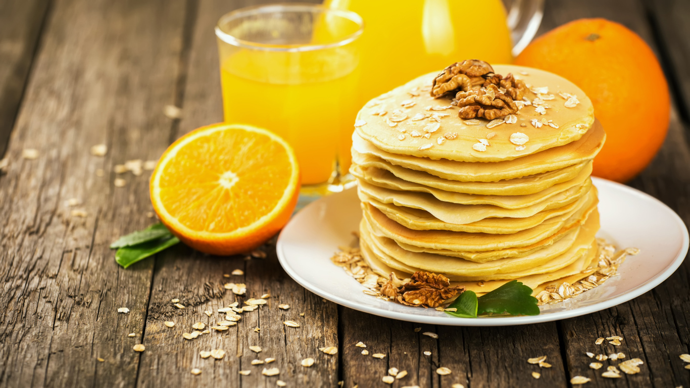 Блины с орехами на столе с апельсиновым соком на Масленицу