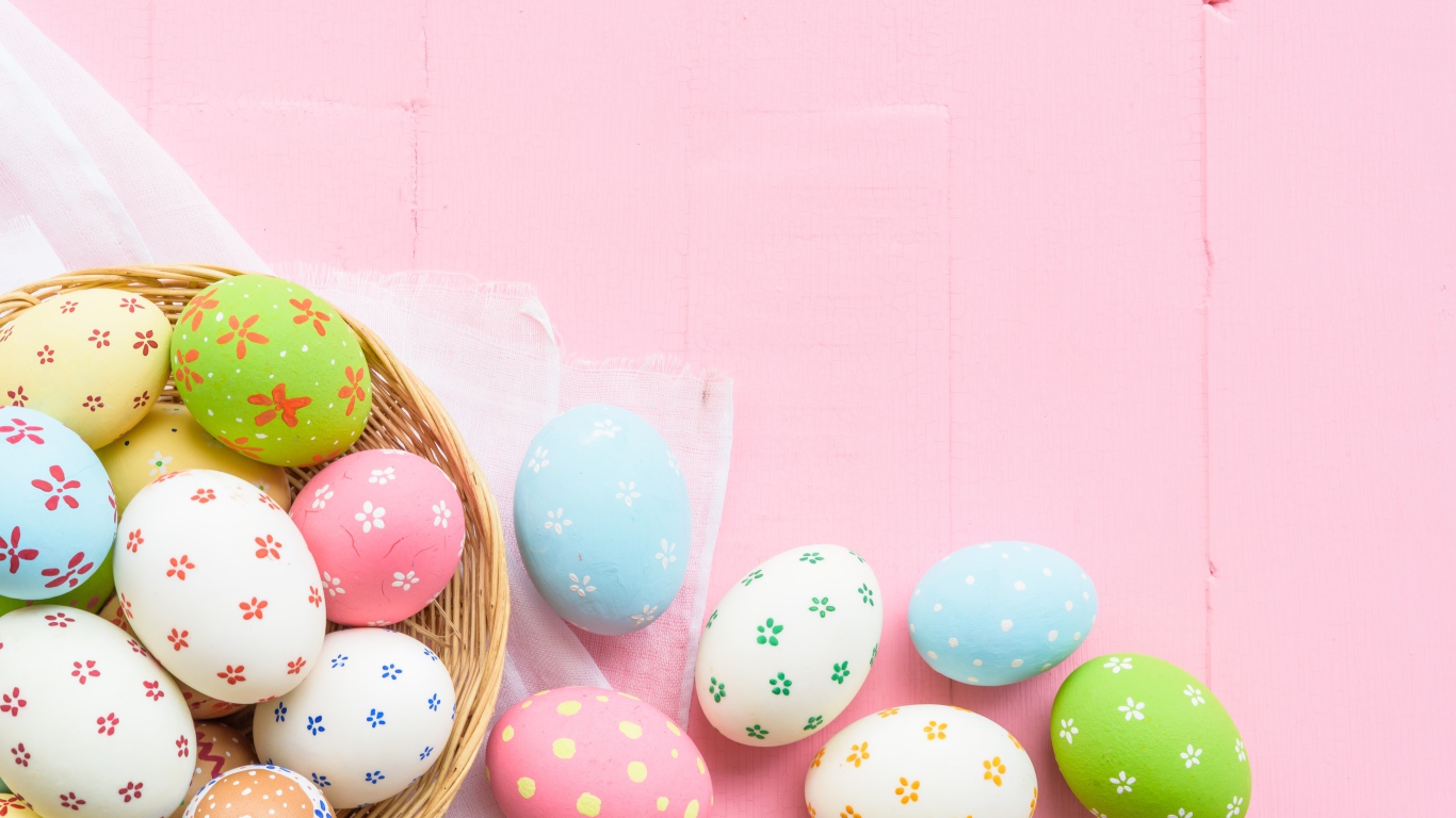 Разноцветные пасхальные яйца на розовом фоне