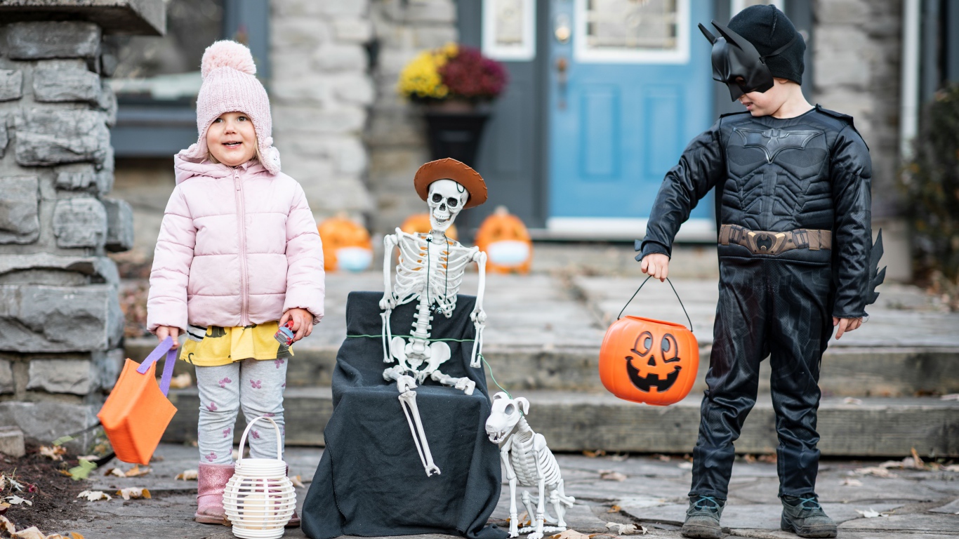 Маленькие дети со скелетом на праздник Хэллоуин