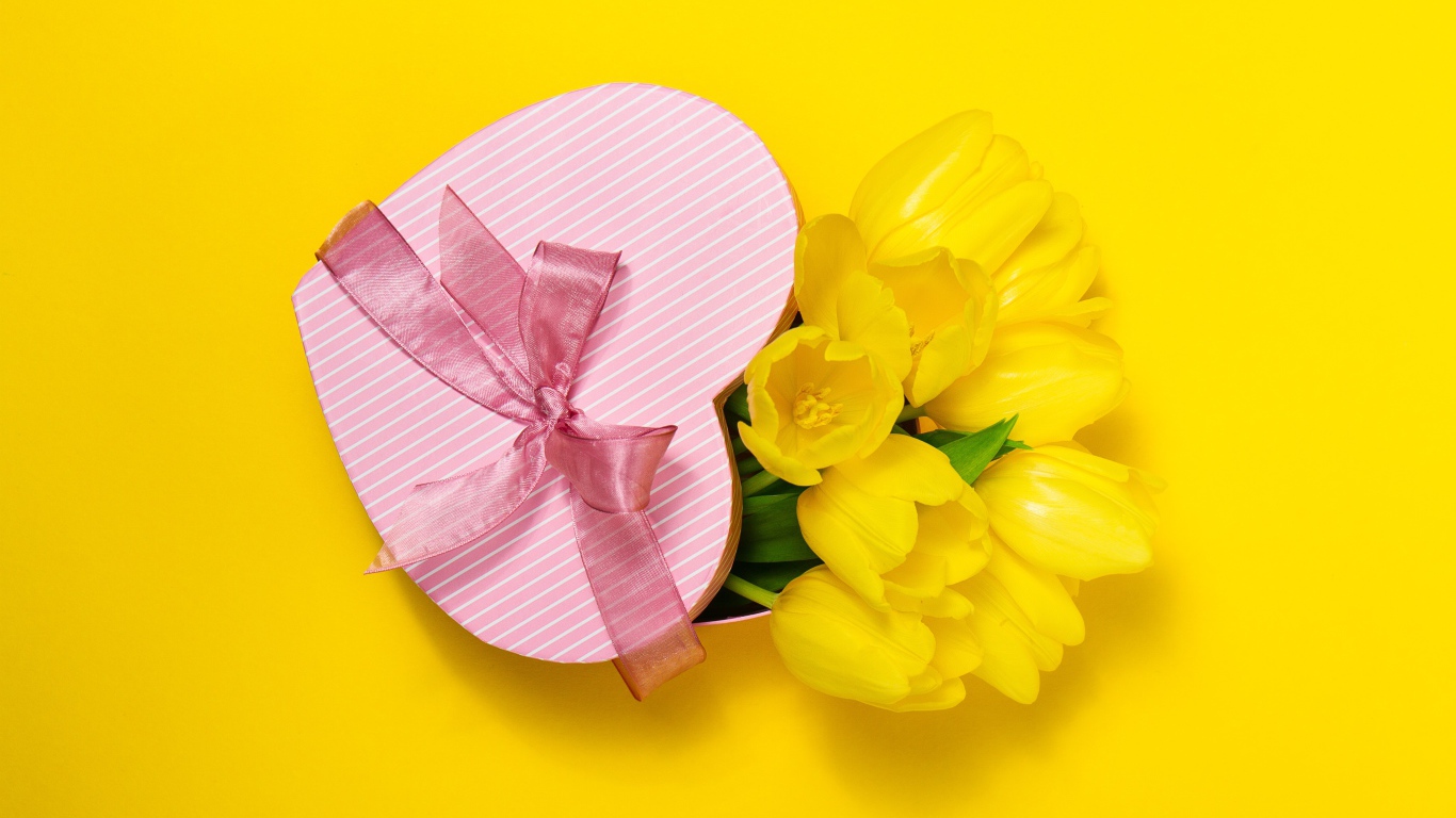 Подарок и букет тюльпанов на желтом фоне на Международный женский день