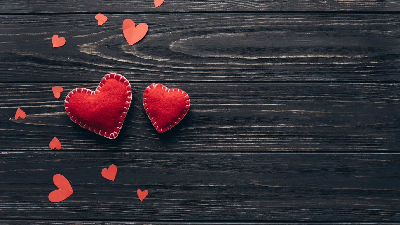 Два больших  красных сердца с маленькими  на деревянном столе 