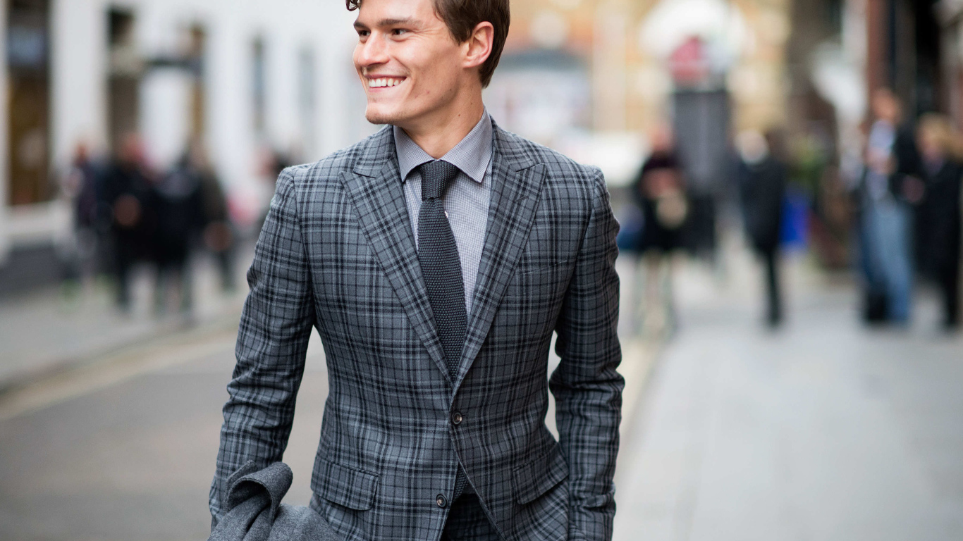 Улыбающийся молодой мужчина в костюме 