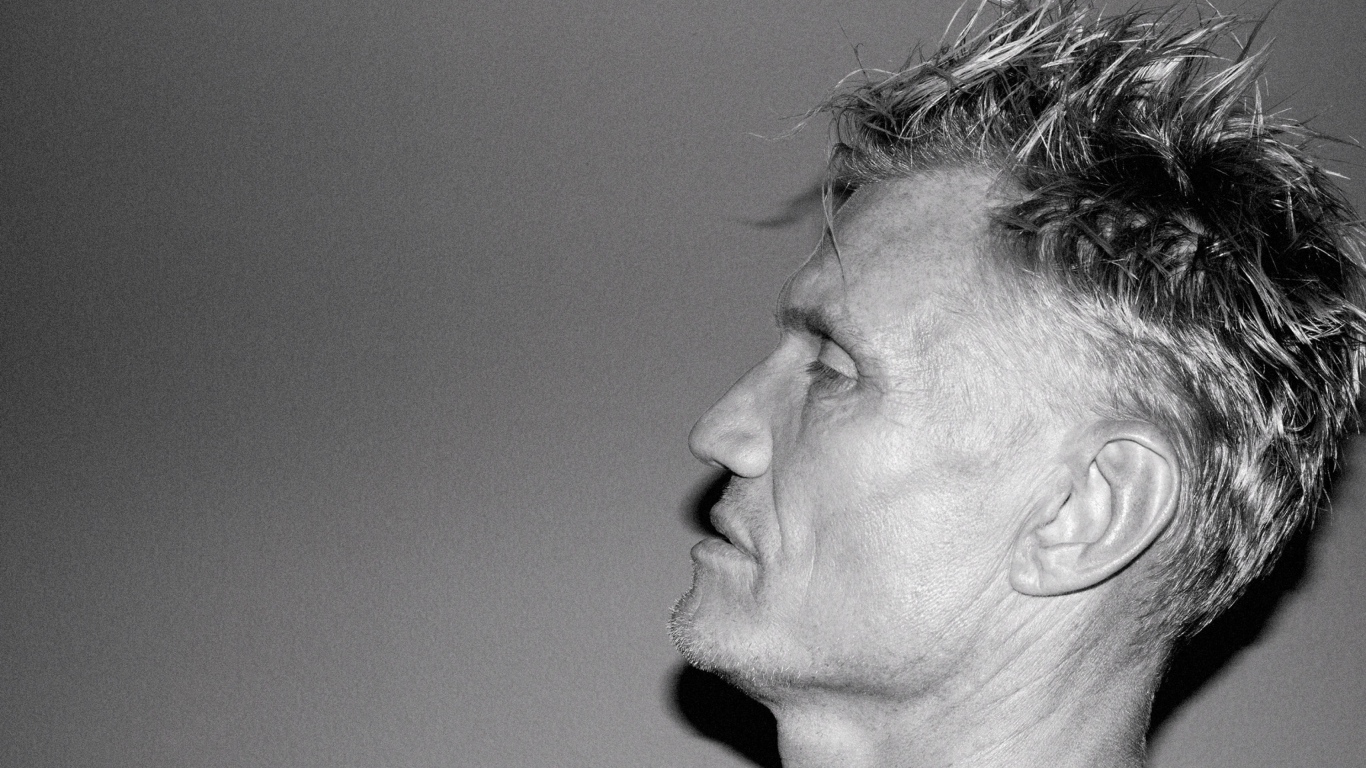 Лицо актера Дольфа Лундгрена боком на сером фоне