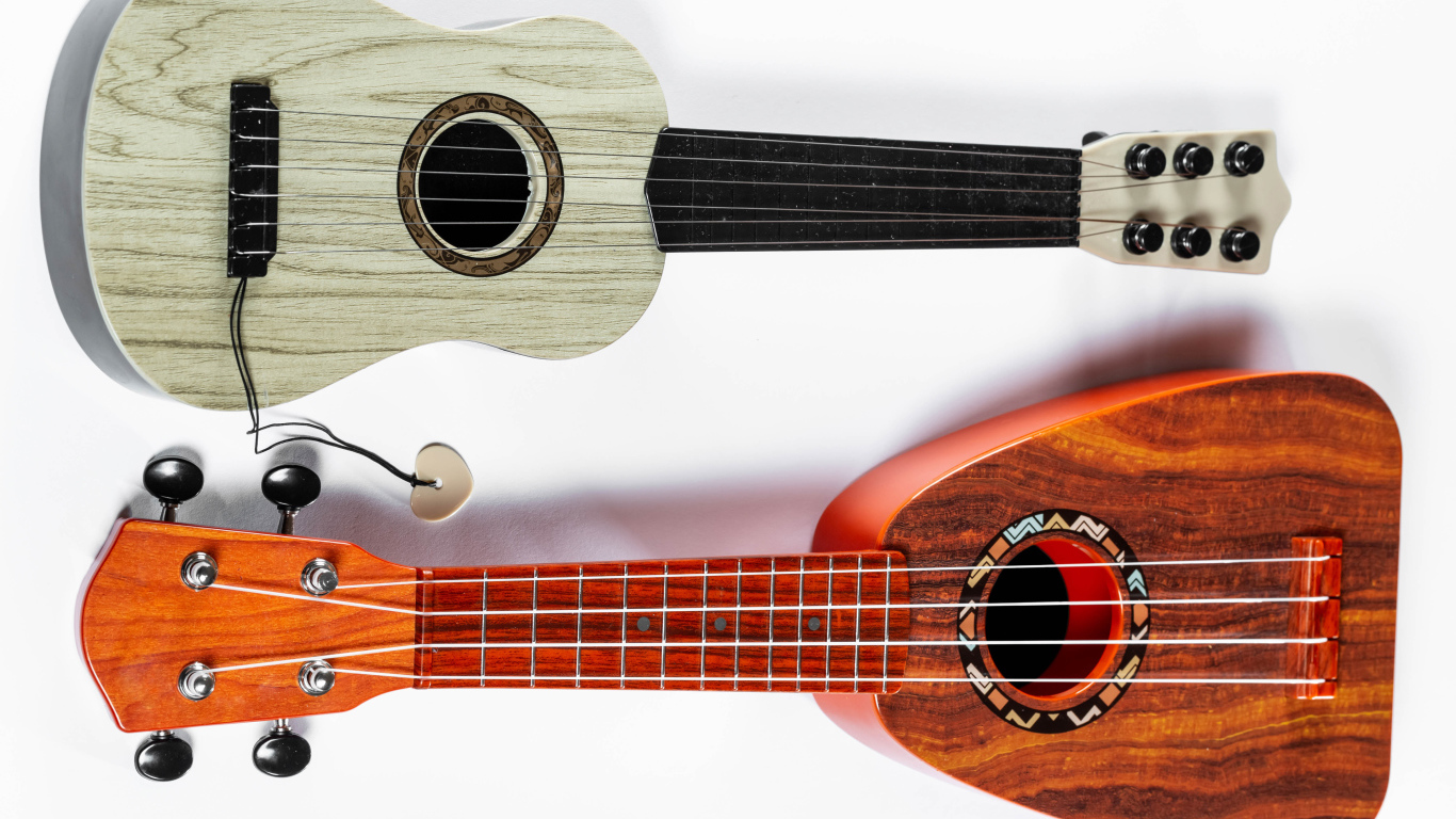 Две маленькие гитары укулеле на белом фоне