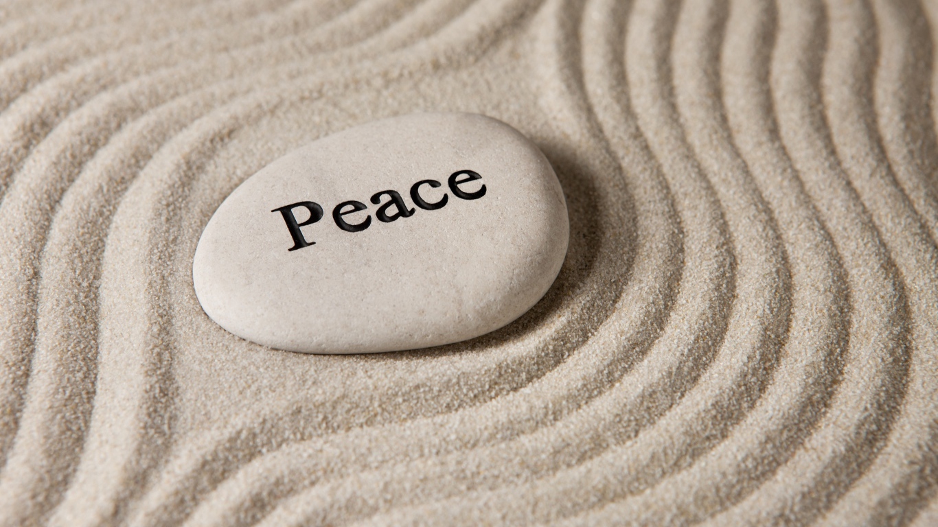 Белый камень с надписью на песке с волнами