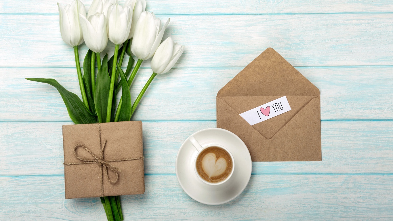 Букет белых тюльпанов на столе с подарком и чашкой кофе