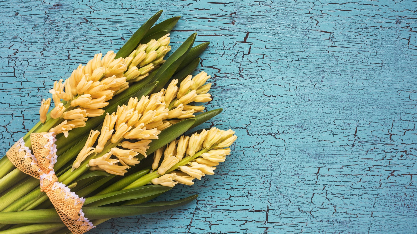 Букет желтых гиацинтов с зелеными листьями на голубом фоне