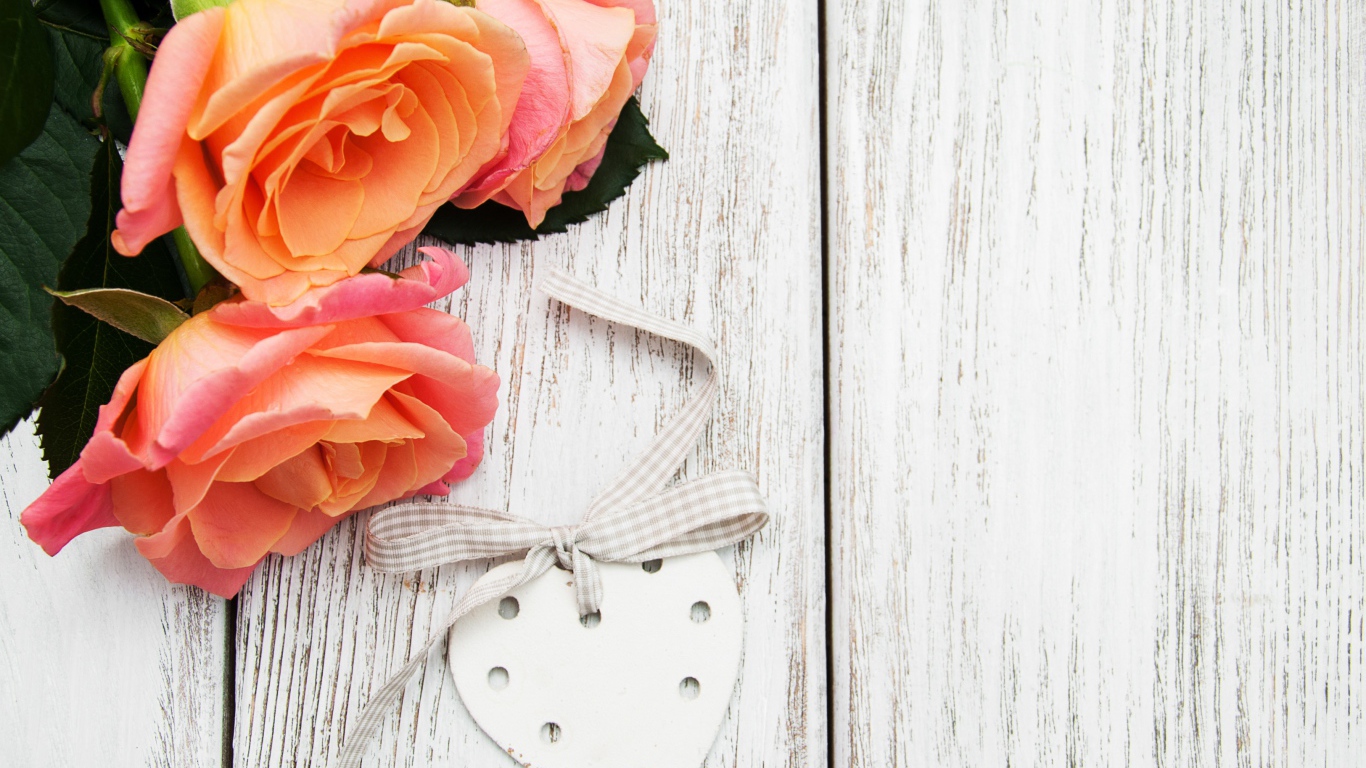 Три оранжевых цветка розы на сером столе