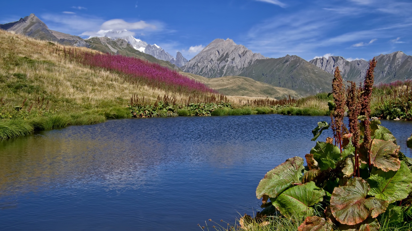 Яркое солнце над горами и озером