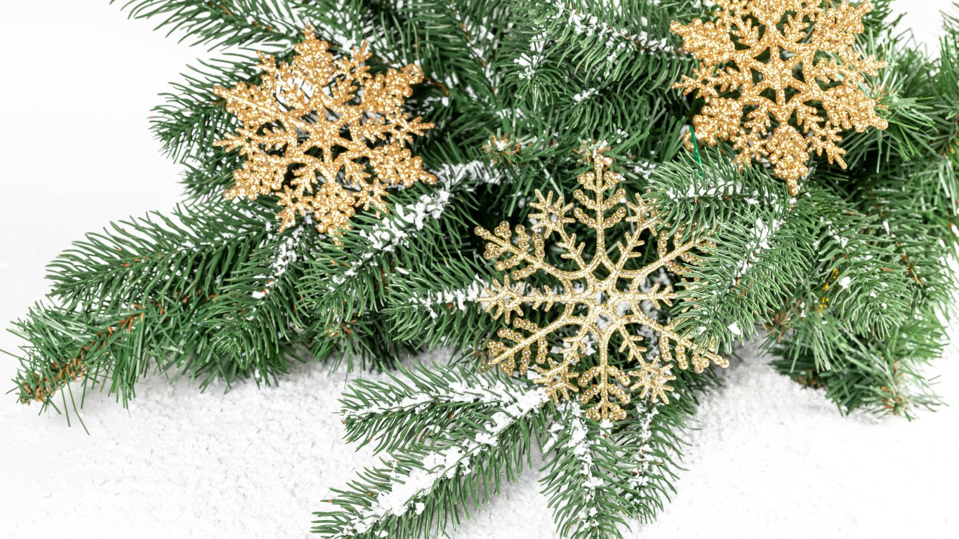 Золотистые снежинки и еловые ветки на снегу