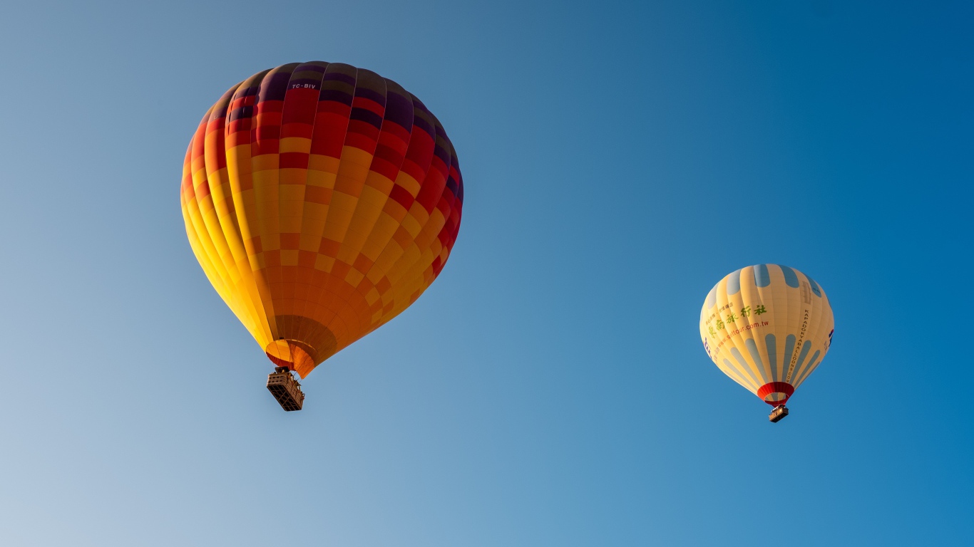 Два больших красочных воздушных шара в голубом небе