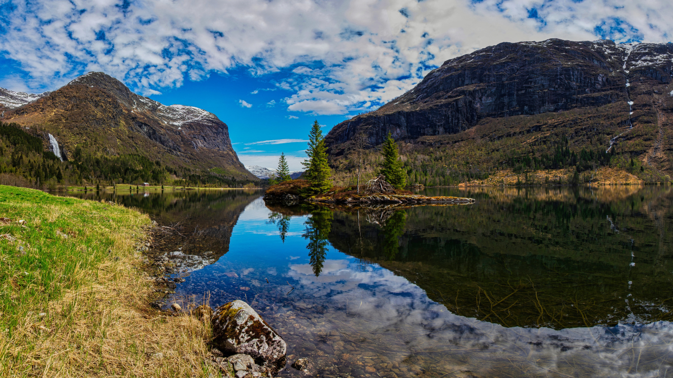 Остров среди озера у гор под красивым небом 