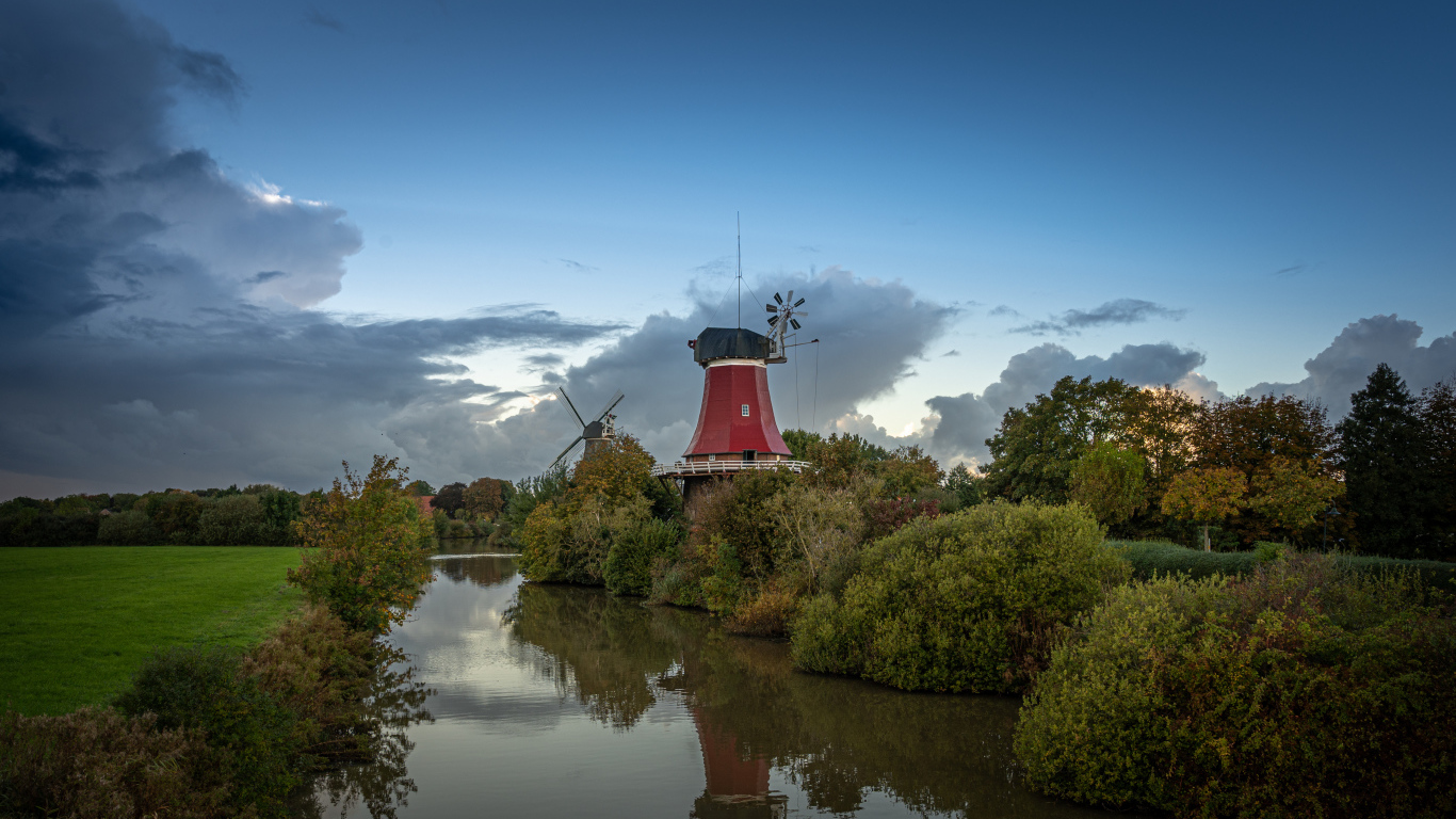 Мельница на берегу реки под красивым небом в сумерках
