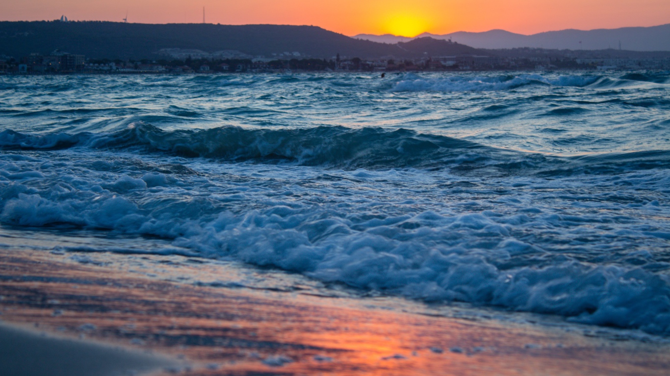 Бушующие волны на берегу моря на закате 