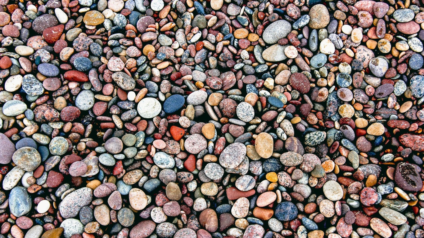 Мелкие разноцветные камни на морском берегу 