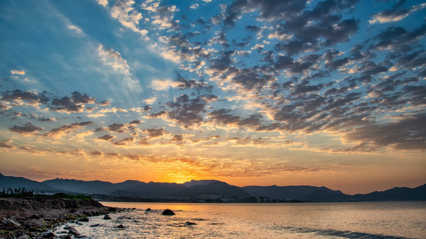 Рассвет солнца за горой у озера 