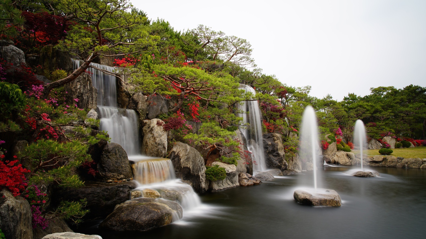 Водопады в красивом саду с зелеными деревьями