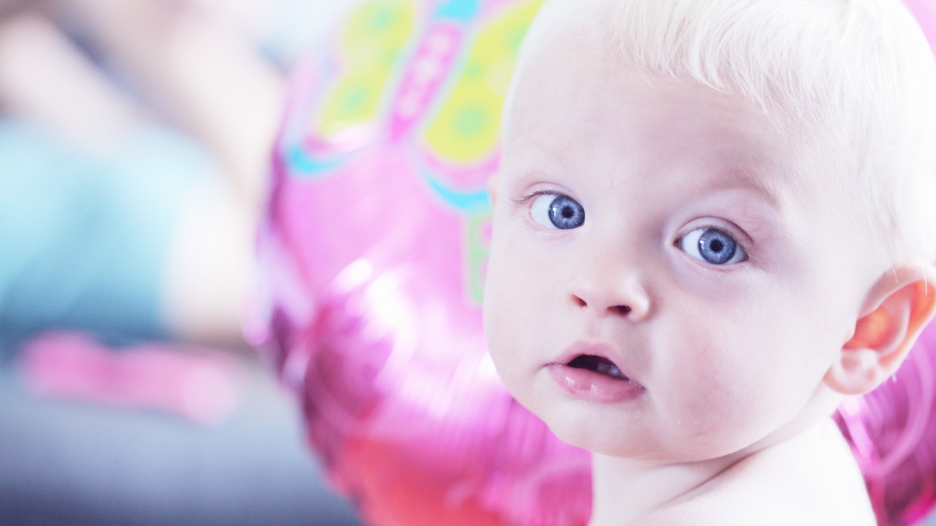 Голубоглазый маленький мальчик на фоне шарика