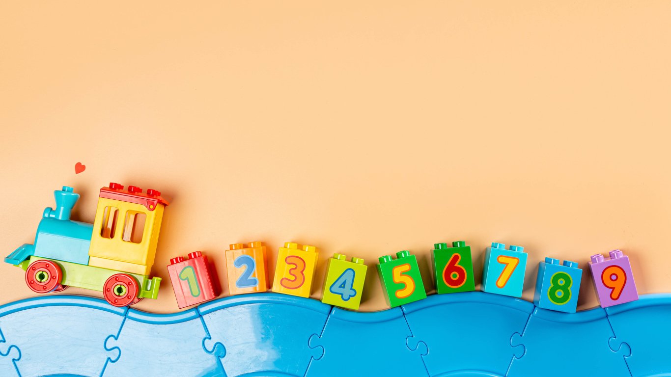 Детский игрушечный паровоз на бежевом фоне 