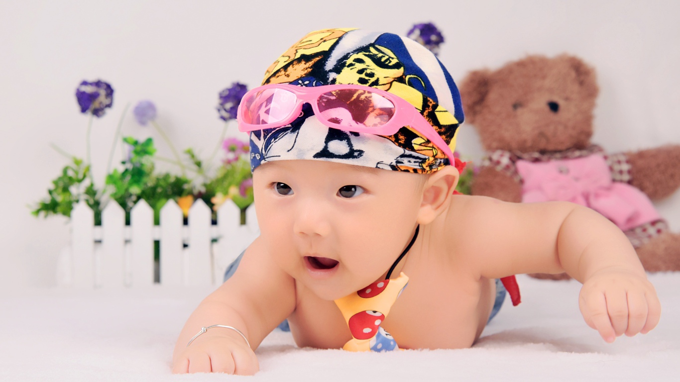 Маленький ребенок азиат в шапке с очками