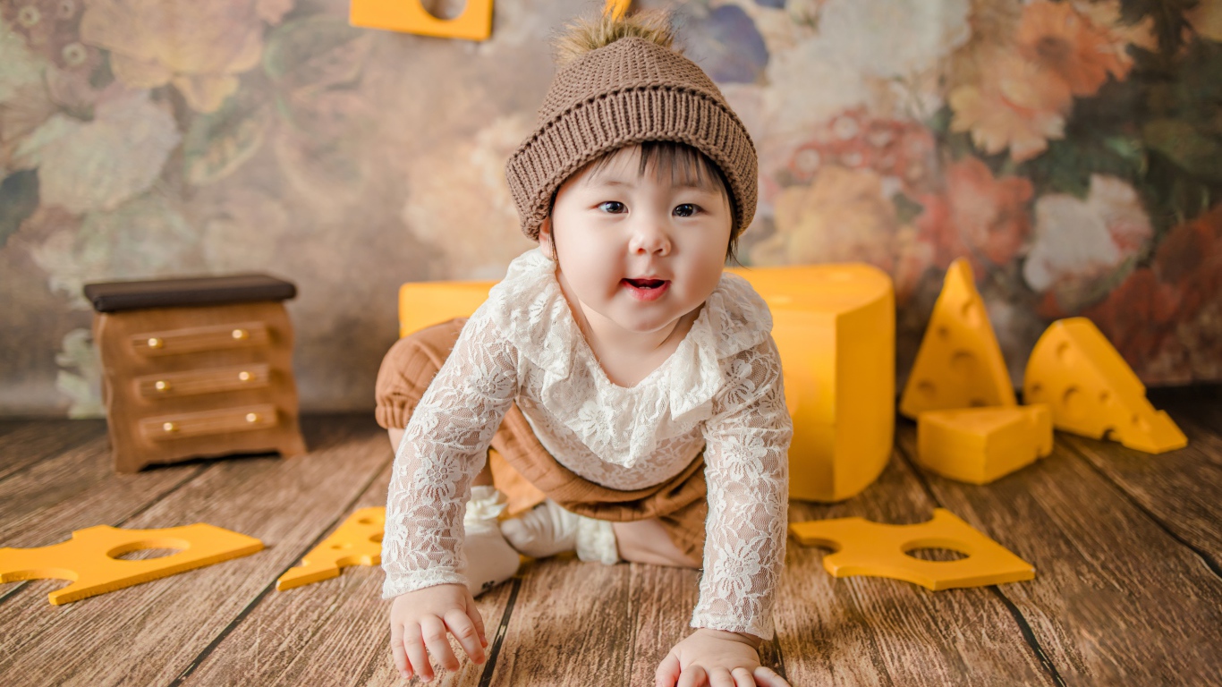 Маленький азиатский ребенок на полу с игрушками