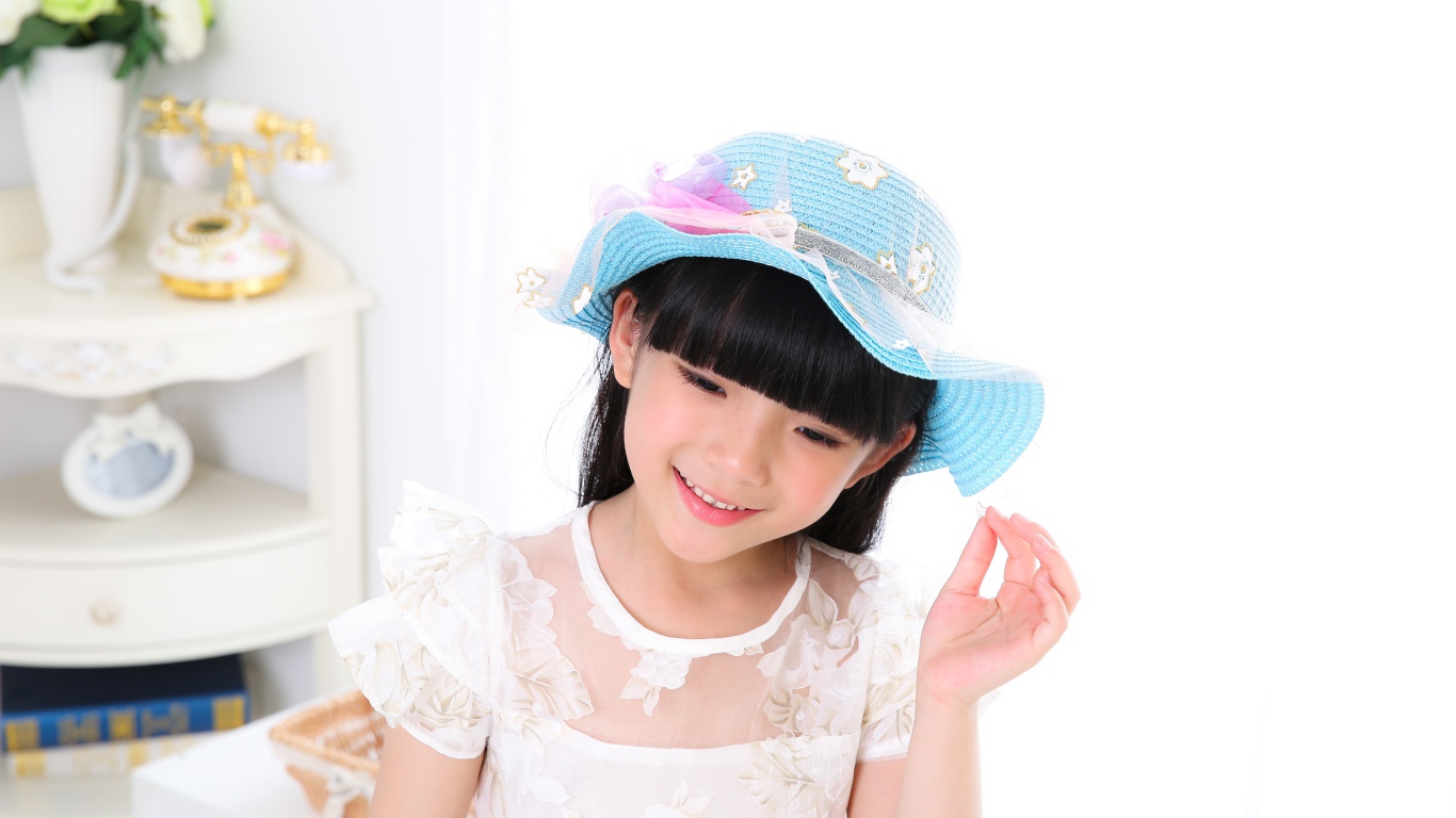 Маленькая девочка азиатка в белом платье 