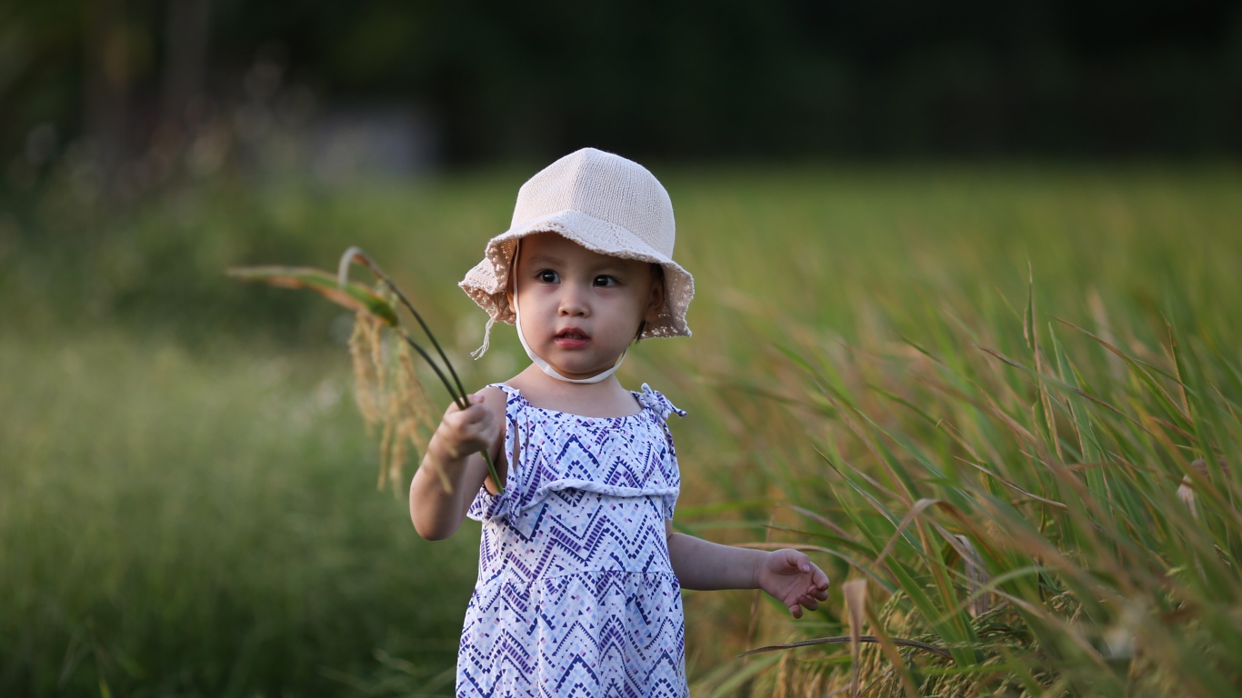 Маленькая девочка азиатка стоит в траве