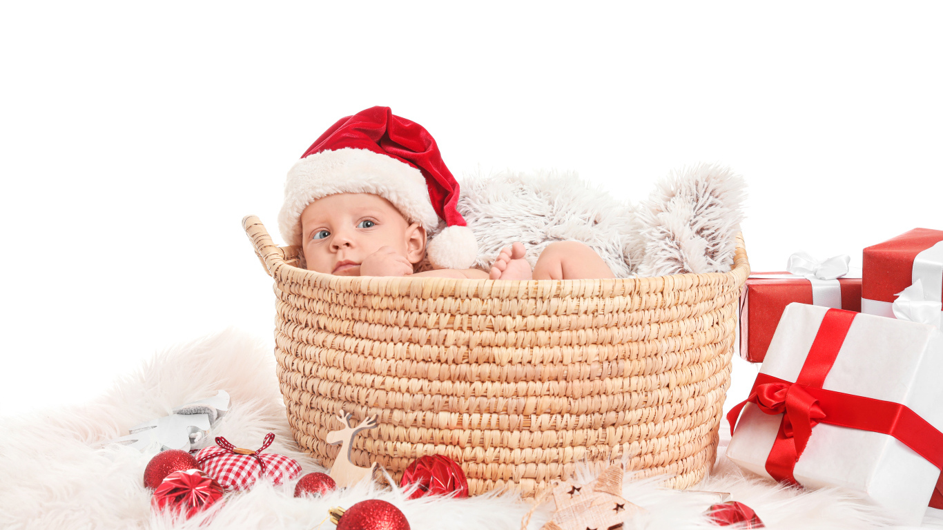 Маленький ребенок лежит в корзине с подарками на новый год